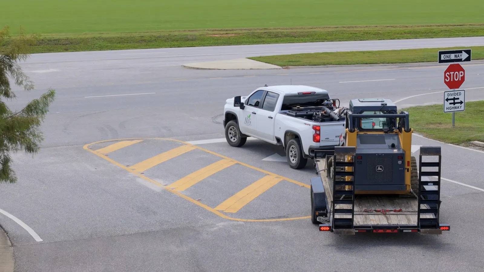 Andrews Lawn & Garden truck towing a trailer with a track loader on it, headed to a job in Baldwin County, Alabama