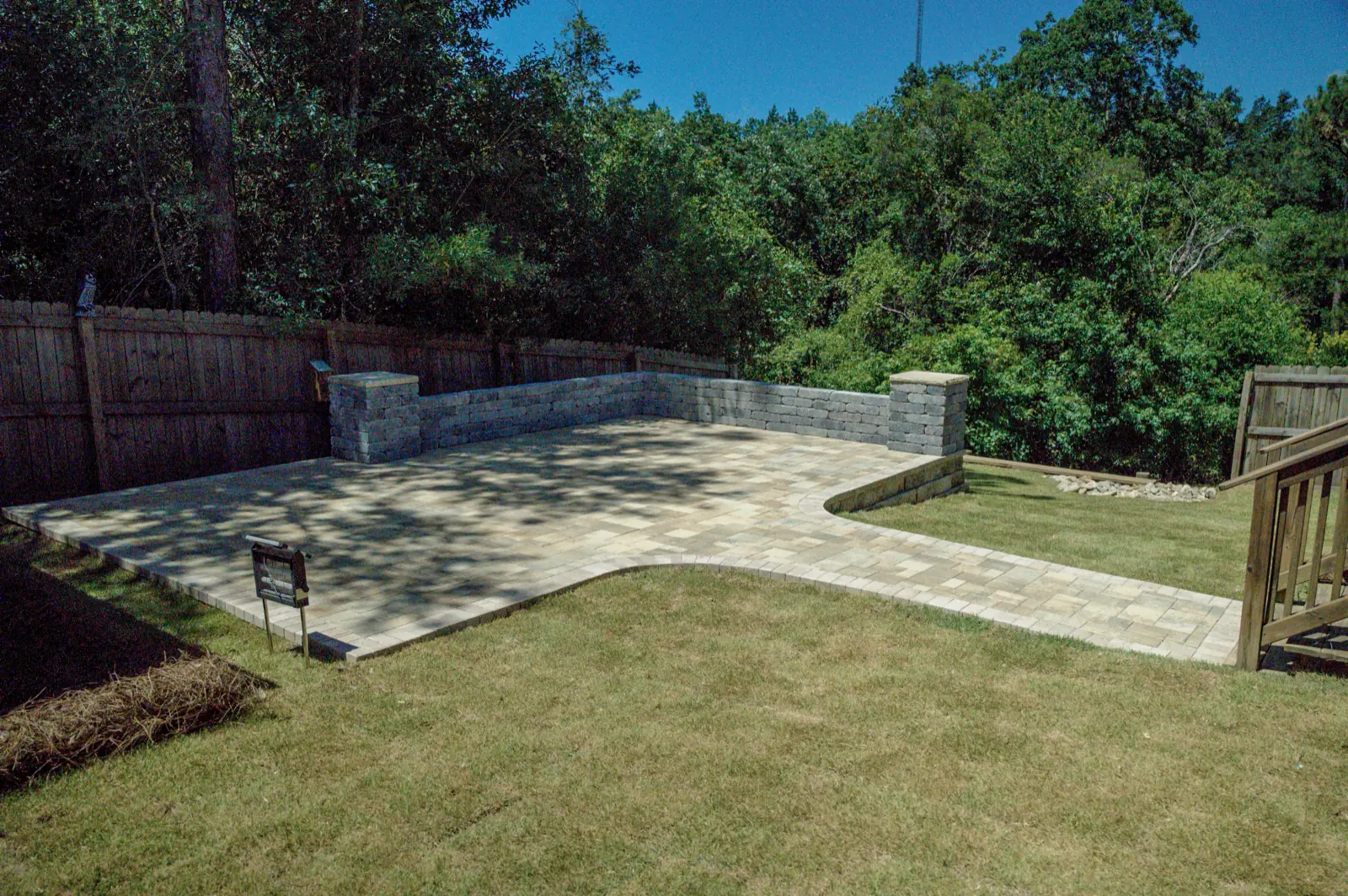 Backyard patio framed by low block walls at a home in Baldwin County, Alabama