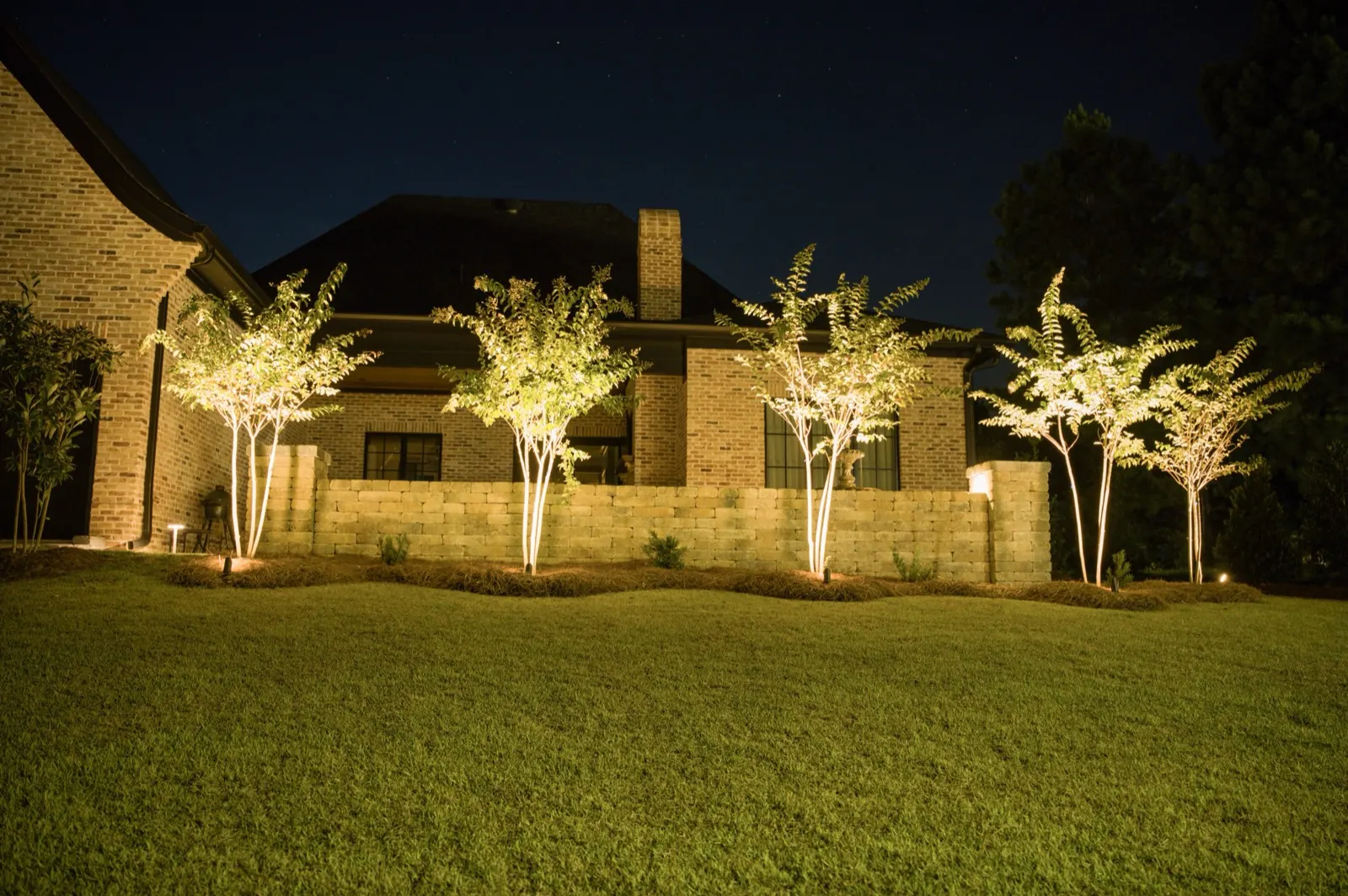 Landscape lighting on a home and front landscape in Fairhope, Alabama at night