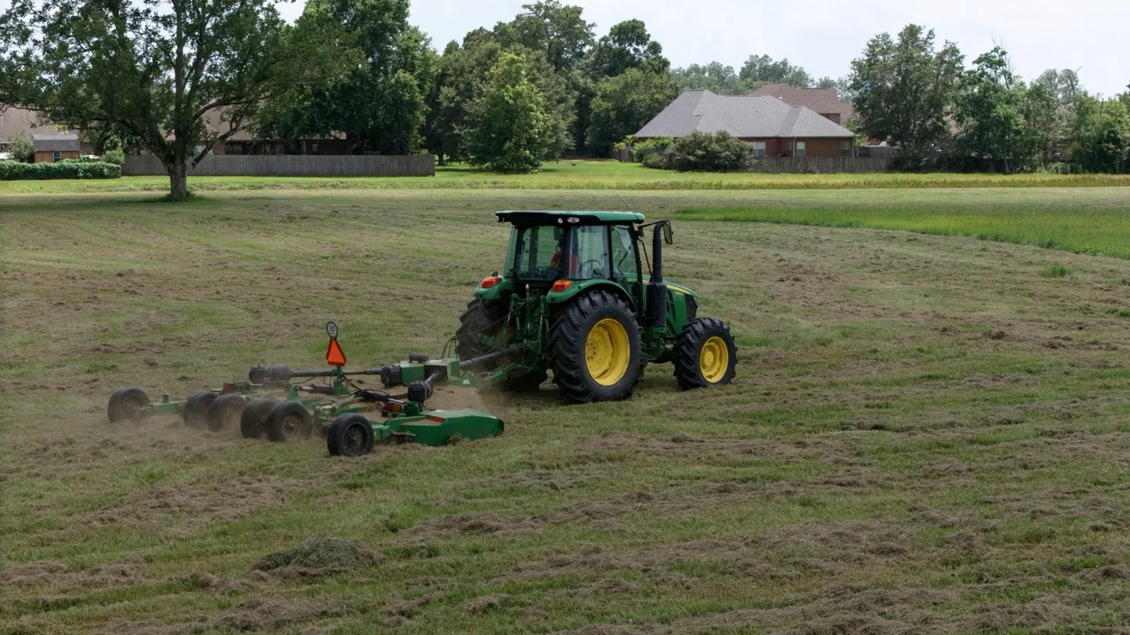 Tractor mowing acreage at a commercial property in Loxley, Alabama