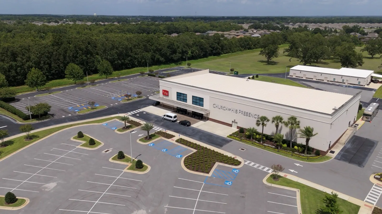 Aerial view of a commercial building and maintained parking islands in Loxley, Alabama